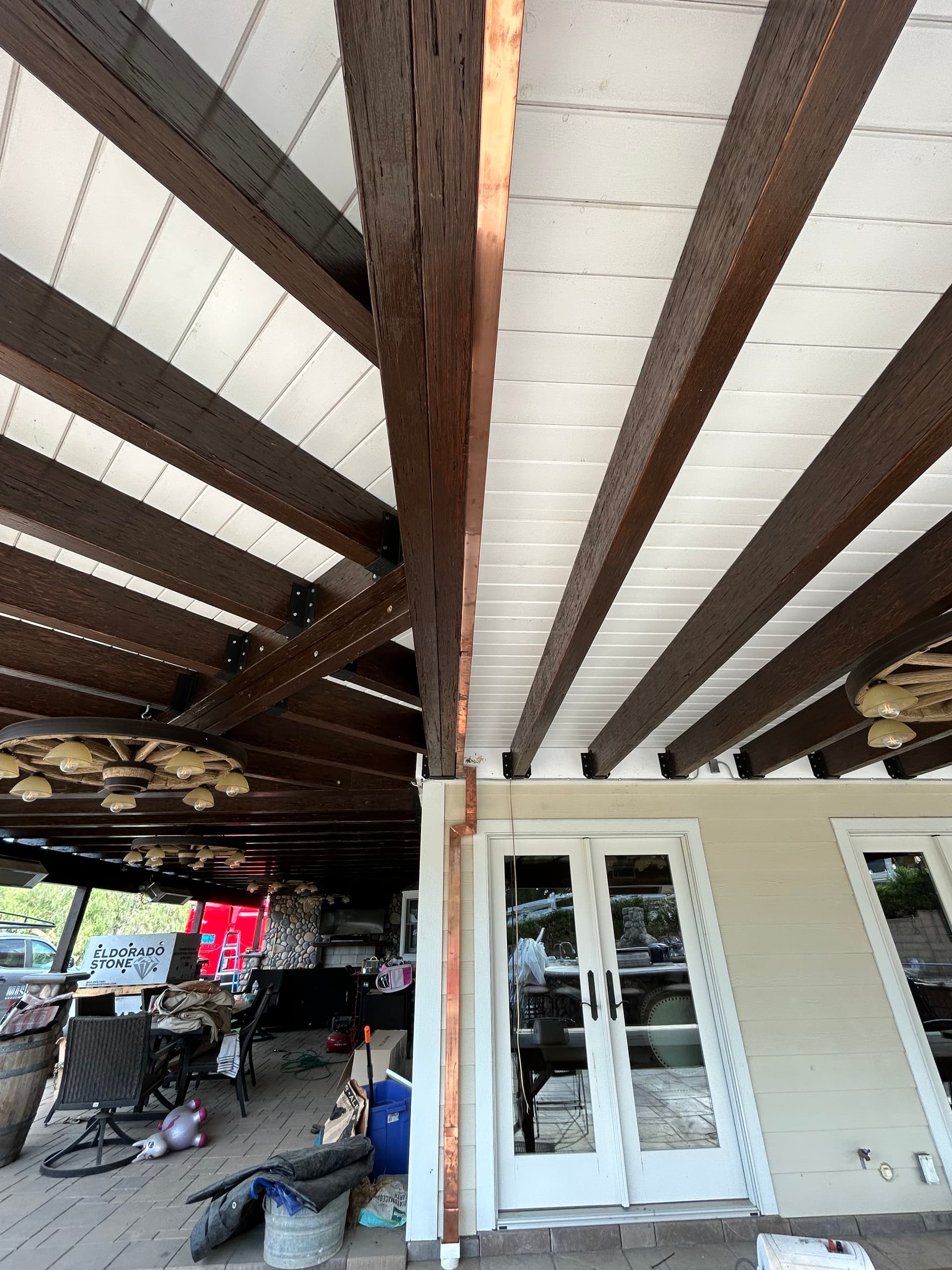 Copper gutter installed along wood beam patio cover on craftsman-style home