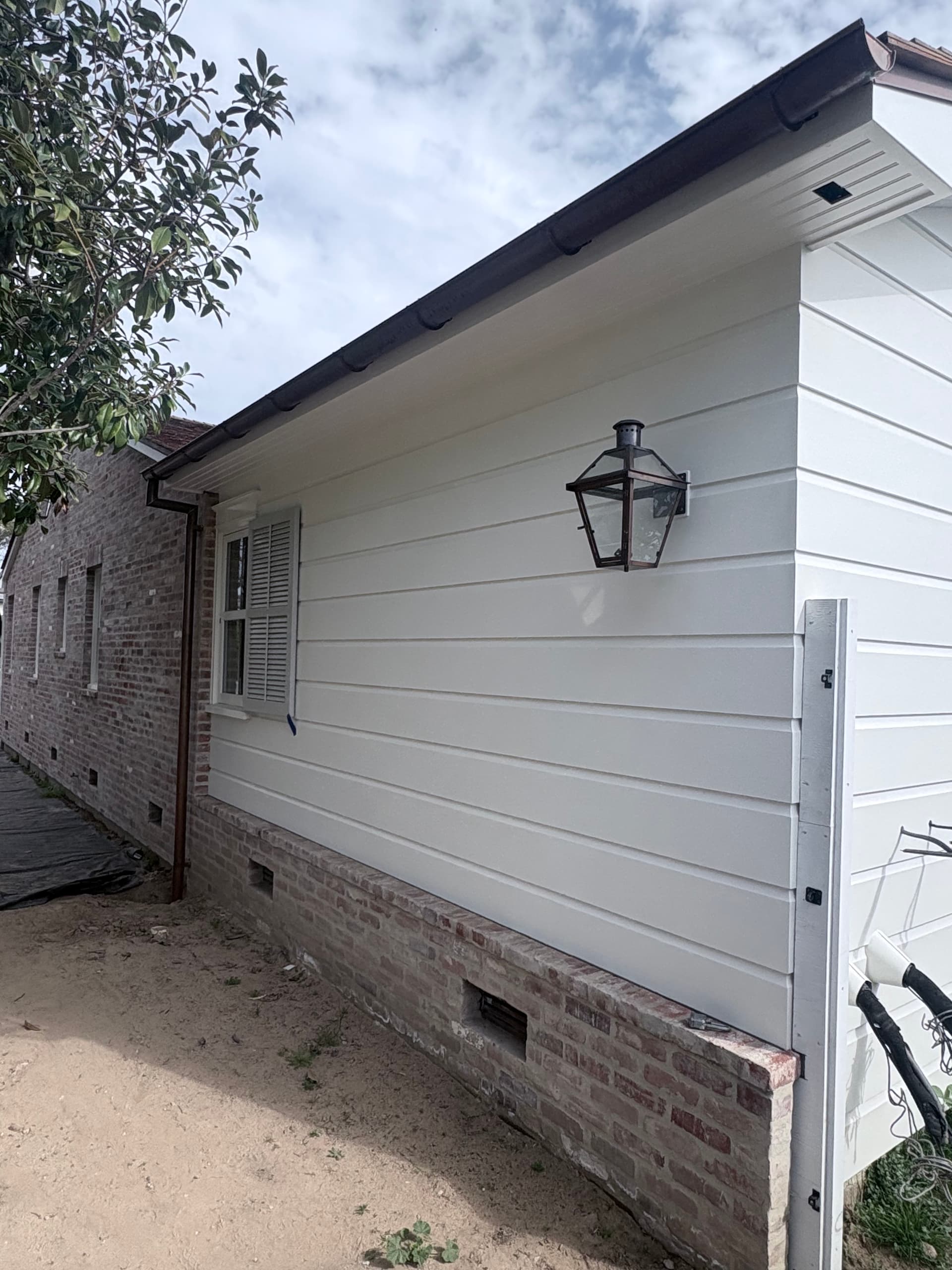 Copper half-round gutter on board-and-batten home with lantern fixture