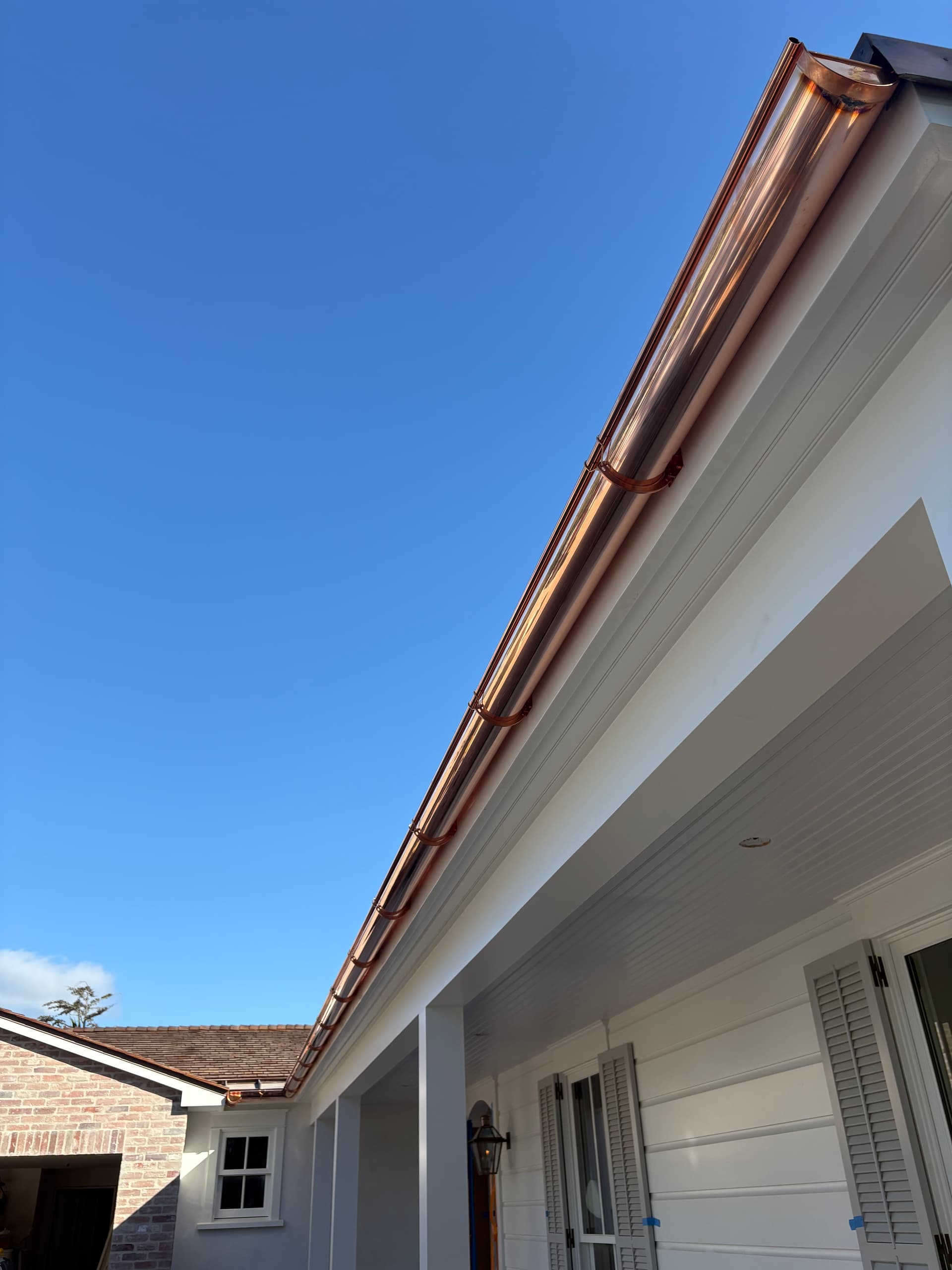 Copper half-round gutter with external brackets close-up view