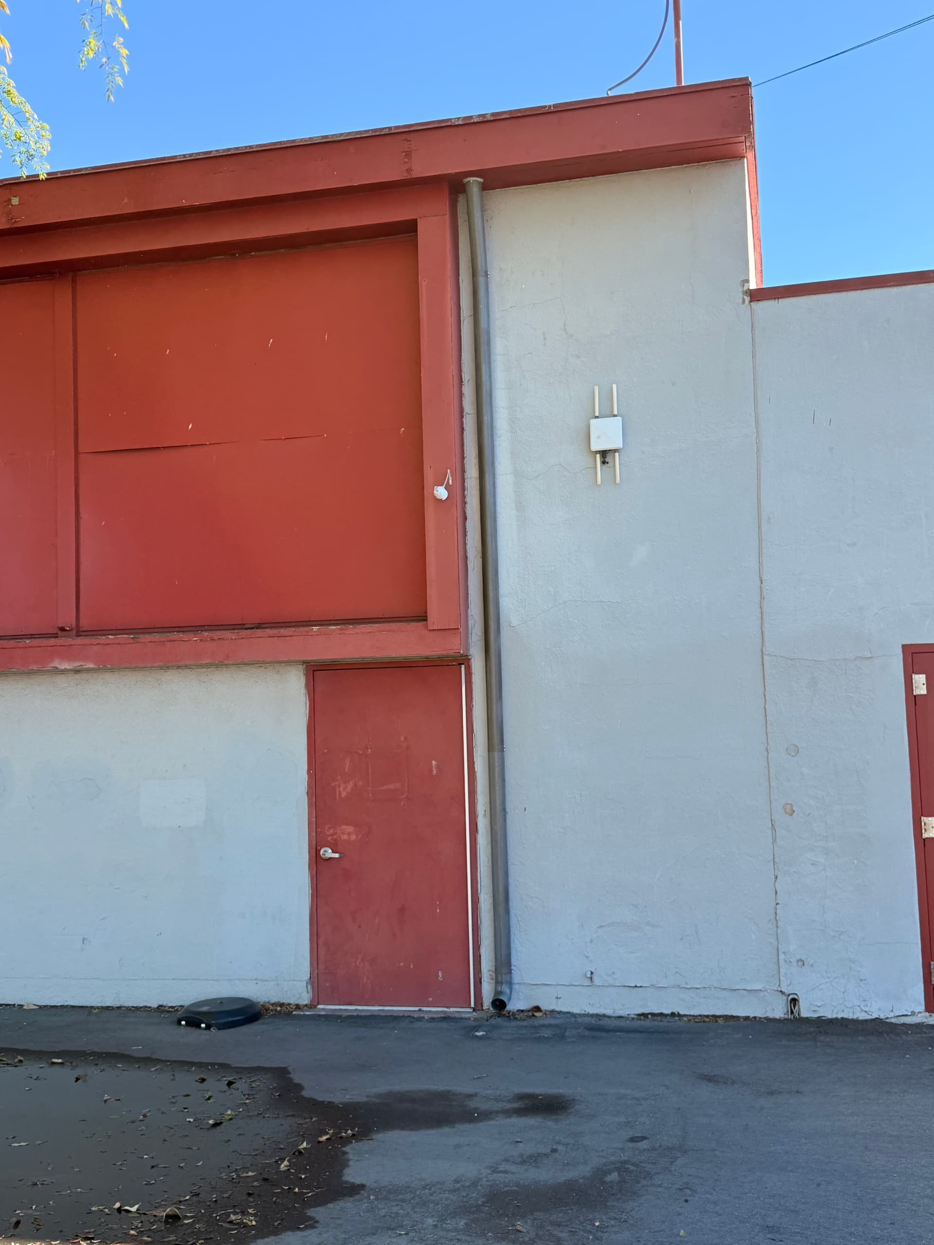 Gutter repair at corner section on commercial building with red and gray exterior